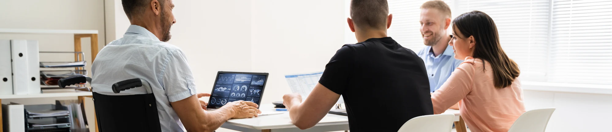 A team at the work meeting including disabled person on a wheelchair